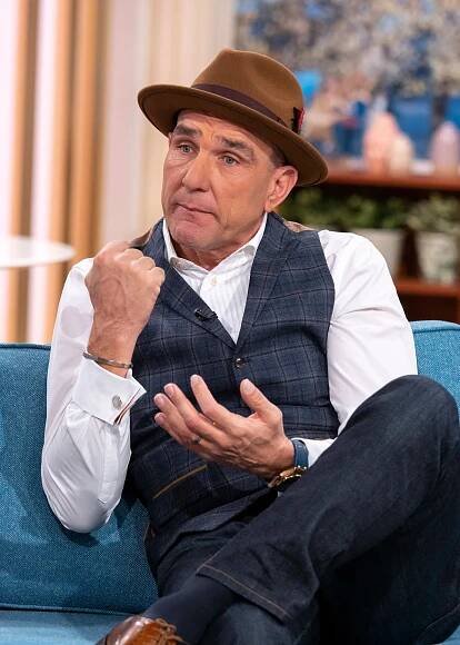 a man wearing a hat is sitting on a blue couch