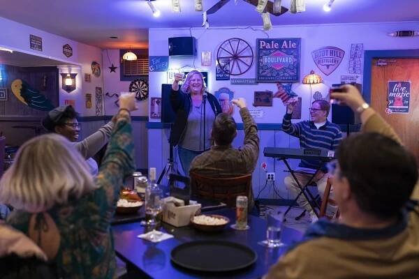 Mary Catherine Garrison, Bridget Everett, Tim Bagley, Jeff Hiller, and Murray Hill all toasting in a bar in the finale of 'Somebody Somewhere.'