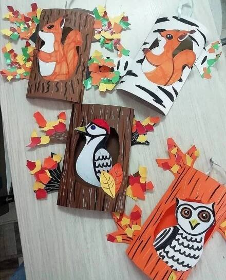 paper cut out animals and trees on a table