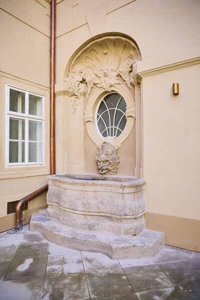 Obr. 08  Restaurátorská obnova fasád se  musela vypořádat s náročnými  úkoly spočívajícími v materiálové  nehomogenitě ploch fasád. Pohled na  kašnu na 2. nádvoří