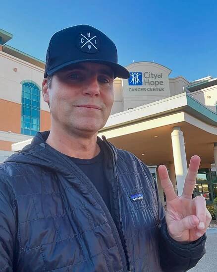 Colin Egglesfield shares a selfie after revealing third cancer diagnosis. Here, he is standing in front of City of Hope Cancer Center, holding up a peace sign.