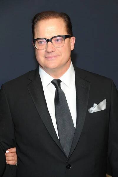 Image may contain Accessories Tie Accessory Glasses Suit Clothing Overcoat Coat Apparel Human Person and Tuxedo