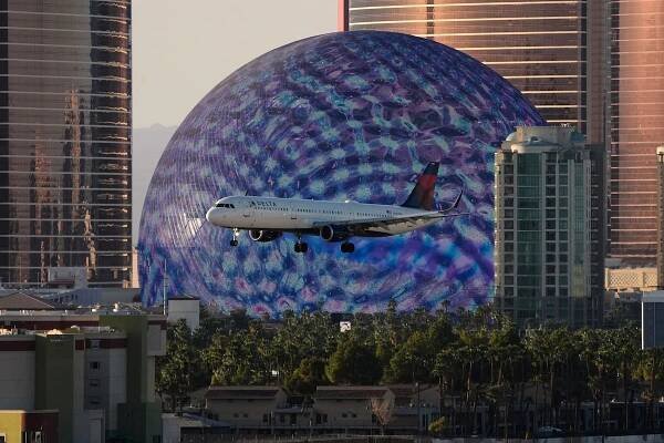 Delta Air Lines flight lands at Harry Reid International Airport, Wednesday, April 9, 2025, in Las Vegas. (AP Photo/John Locher)