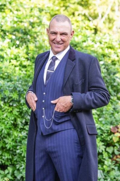 a man in a suit with his hands in his pockets