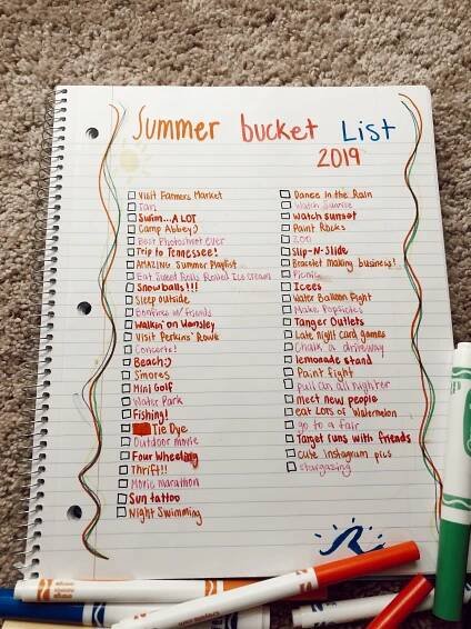 a summer bucket list with markers and pens on the floor next to it is lined up