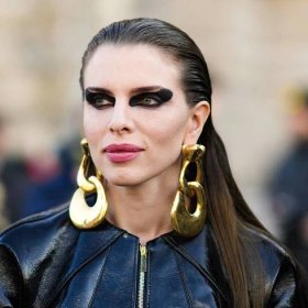 Julia Fox seen outside Schiaparelli during Paris Fashion Week wearing dramatic black eye makeup and gold statement earrings