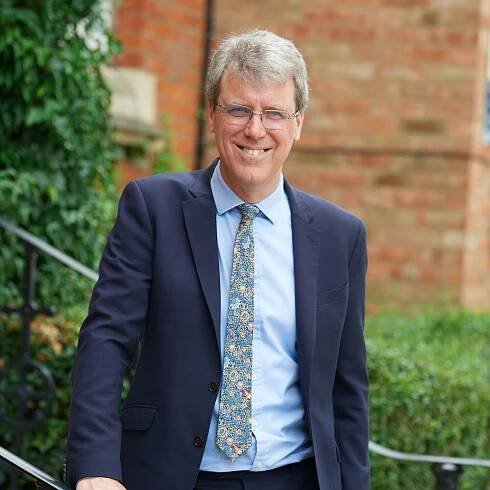 Mark Turner, Head, poses for a photo in front of the school.