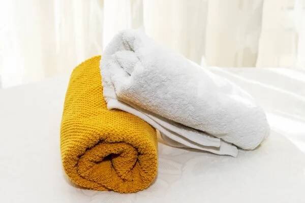 Mnohobarevný ručník na bílém stole na pozadí okna — Stock obrázek