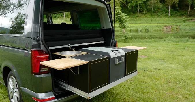 the back end of a green van with an oven in it