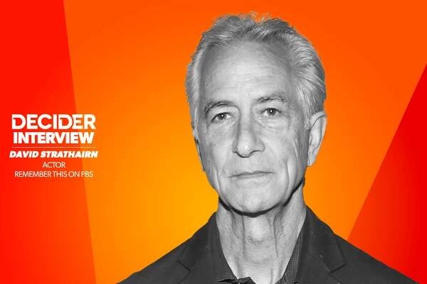 David Strathairn in black and white on a bright orange background