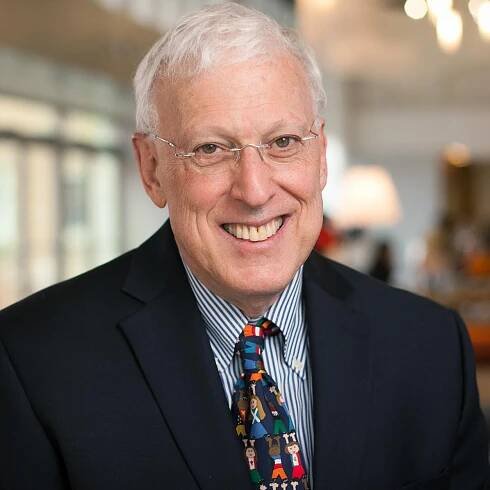 man wearing a colorful tie smiling at the camera