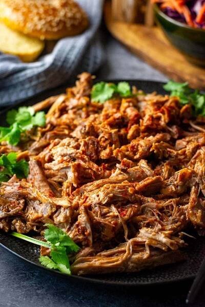 Slow cooked BBQ Pulled pork on a black plate. 