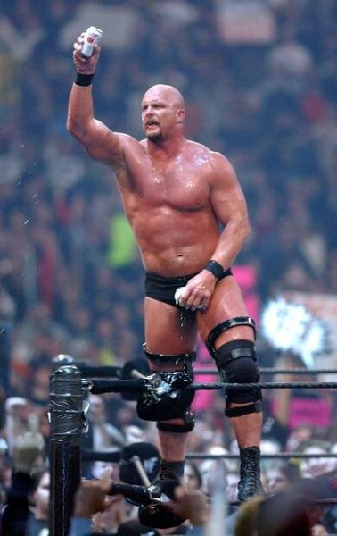 a man in a wrestling ring holds up a can of diet coke