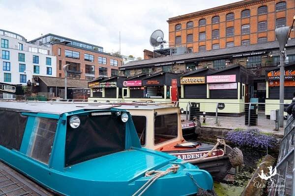Boats docked in front of food stalls at Camden Town Lock in Camden 