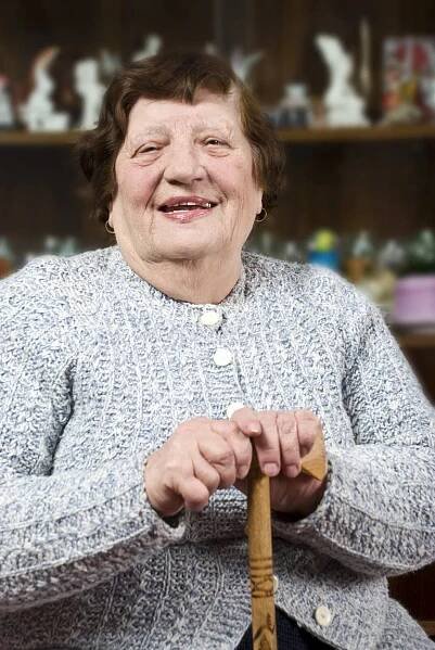 Smiling grandma holding a stick and sitting on chair in her living room,check also. Grandma stock images, royalty-free photos and pictures