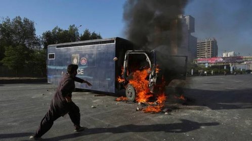 A man runs past a burning prison van set on fire by angry supporters of Pakistan&#39;s former Prime Minister Imran Khan during a protest against the arrest of their leader, in Karachi, Pakistan 
Pic:AP