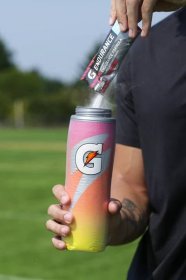 Athlete pouring Gatorade endurance powder into a Sweet Fire Insulated Squeeze Bottle