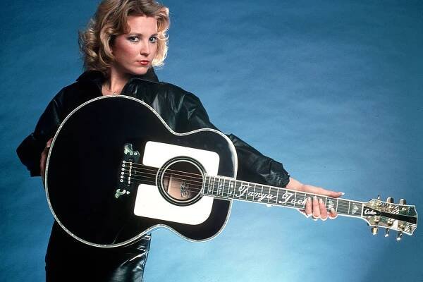 (Original Caption) : 1978- Picture shows country singer, Tanya Tucker, holding a guitar to the side and wearing a black leather suit. (Photo by Lynn Goldsmith/Corbis/VCG via Getty Images)