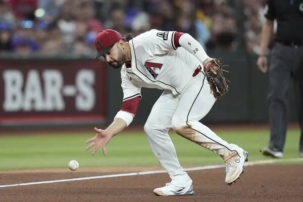 Arizona Diamondbacks third baseman Eugenio Suárez picks up a grounder but is unable to make a throw on an infield single hit by St. Louis Cardinals' Jordan Walker during the seventh inning of a baseball game Sunday, July 20, 2025, in Phoenix. 