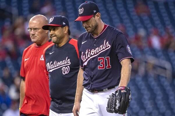 Max Scherzer walks off the field with Nationals manager Dave Martinez and a team trainer after suffering an injury just 12 pitches into his outing.