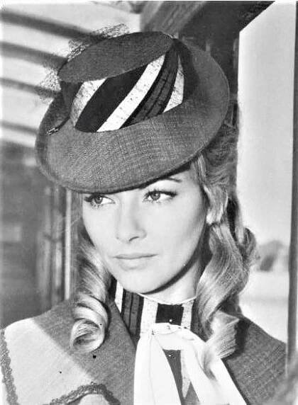 black and white photograph of a woman wearing a hat with ribbons on it's neck