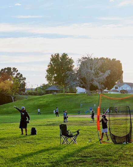 People set up to play a field game in a park