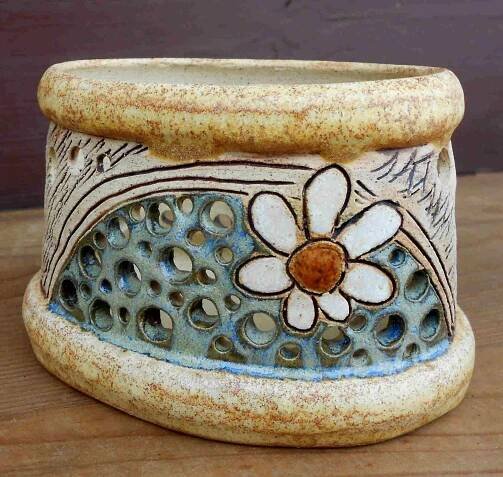 a ceramic flower pot sitting on top of a wooden table