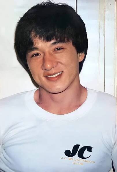 a young man wearing a white shirt and smiling