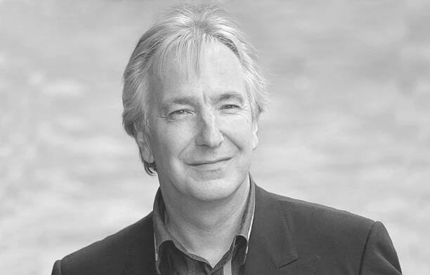 Alan Rickman standing on a red carpet