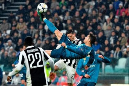 Real Madrid&apos;s Portuguese forward Cristiano Ronaldo (C) overhead kicks and scores during the UEFA Champions League quarter-final first leg football match between Juventus and Real Madrid
