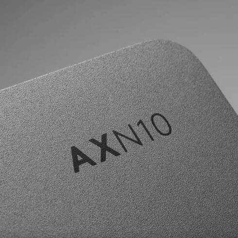 Close-up of the textured metallic surface of a Cambridge Audio AXN10 network player, showing the model name "AXN10" engraved in black.