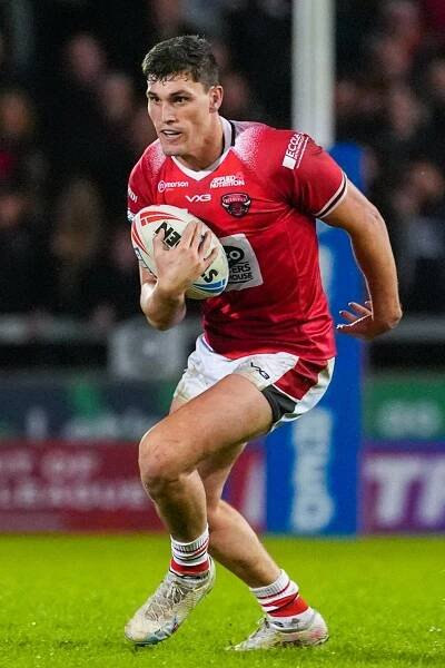 Salford Red Devils player running with rugby ball.