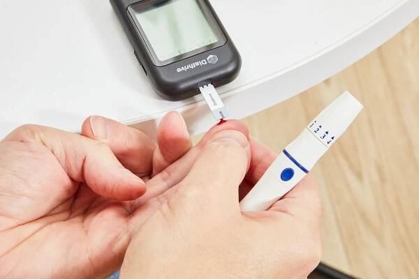 Hands using a Diathrive Blood Sugar Test Kit & Blood Glucose Monitoring System