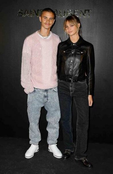Romeo Beckham and Mia Regan attend the Saint-Laurent Womenswear Fall/Winter 2022/2023 show as part of Paris Fashion Week on March 01, 2022 in Paris, France