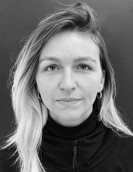 A black and white headshot of Joanna Poupaki she/her
