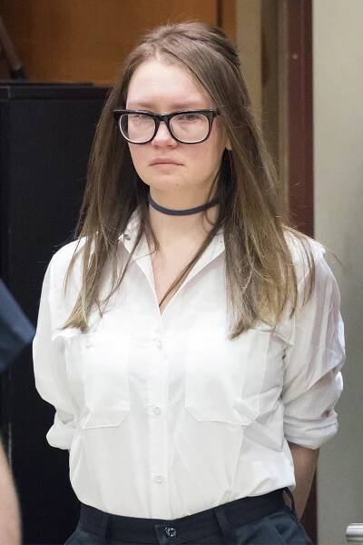 Anna Sorokin in black glasses and a white oxford shirt