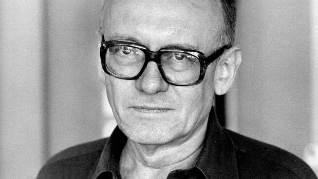 Schwarzweiß-Foto von Ernst Jandl, der ernst in die Kamera blickt