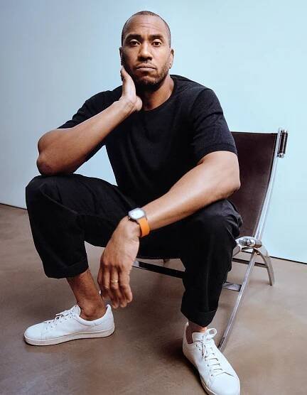 Image may contain Rashid Johnson Person Sitting Clothing Footwear Shoe Adult Wristwatch Sneaker Head and Face