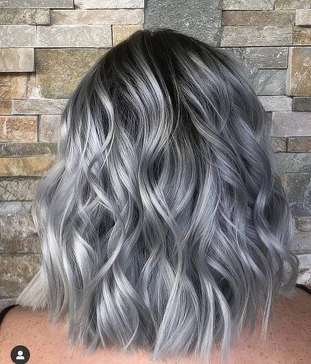 medium length black hair with a lot of silver grey accents and waves looks amazing and very chic