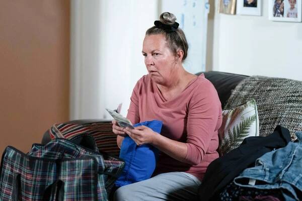 Karen Taylor counting money on a sofa.
