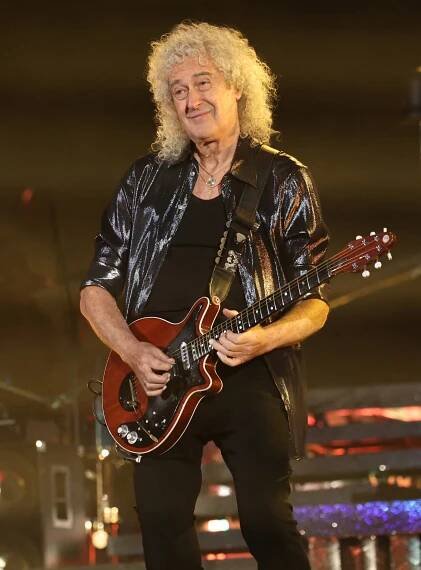 Brian May of Queen performing on stage.