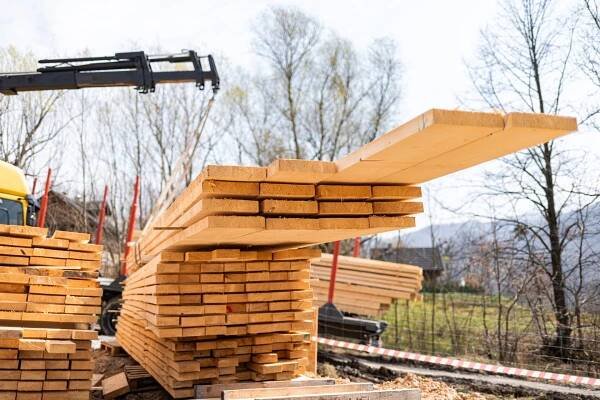unloading-wooden-beams-from-truck-on-construction-2024-10-31-02-08-51-utc-min.jpg