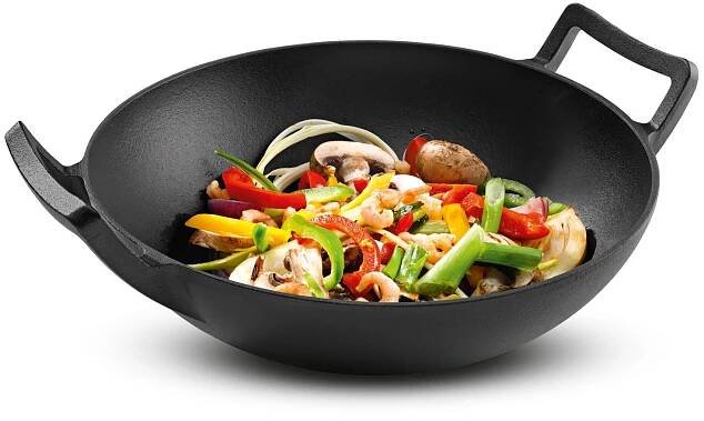 Černá litinová wok s restovanými zeleninou a krevetami