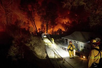 Firefighters protect a home in the Berryessa Estates neighborhood of unincorporated Napa County, California.
