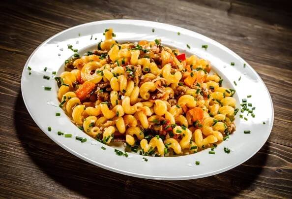 Cavatappi pasta with meat, tomato sauce, and vegetables.