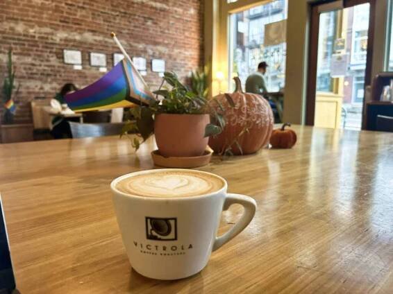 A cup of latte on the wooden table in Victrola Coffee Roasters