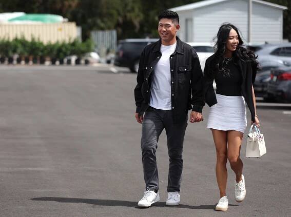 Colin Morikawa and his wife walking hand-in-hand.