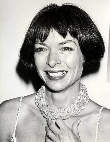 a black and white photo of a woman wearing a necklace