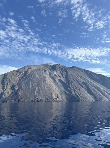 Aktivní sopka Stromboli na pozadí modré oblohy a moře.