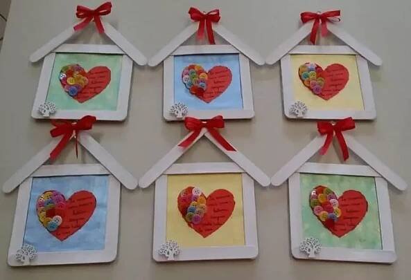 four frames with hearts are hanging on the wall in front of each other, decorated with red ribbons and bows